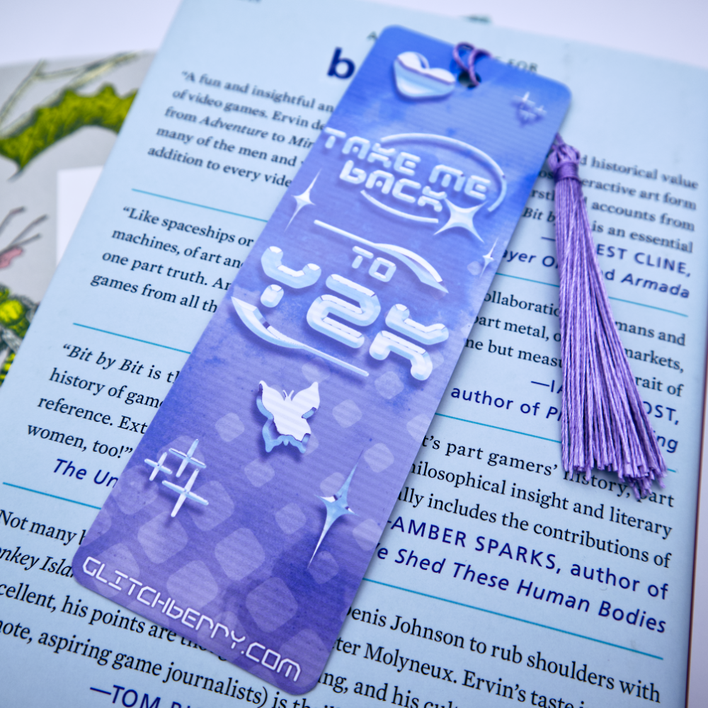 Blue bookmark with with the text "Take me back ty Y2k" and a tassel on a book page