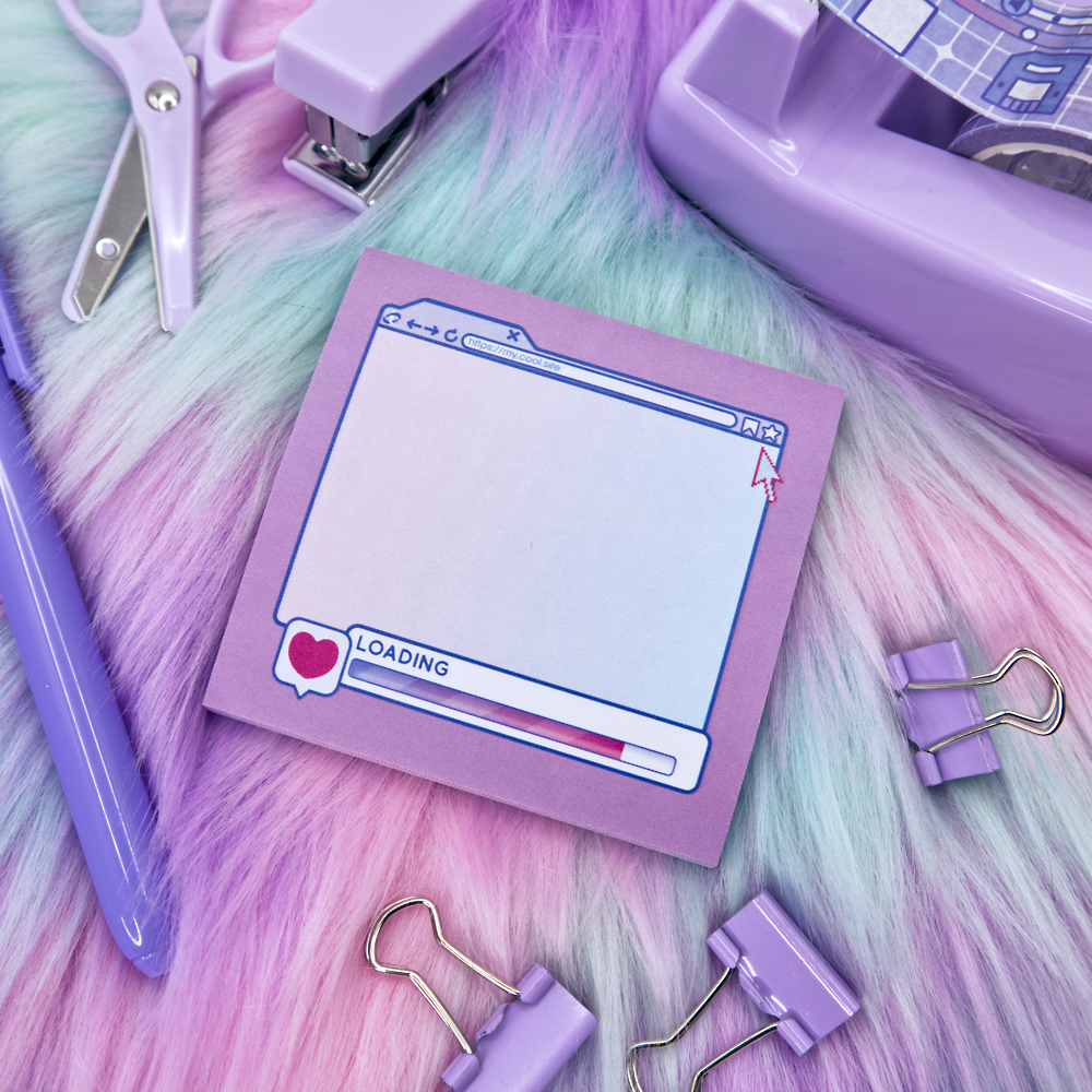 Pink sticky note pad with an internet browser loading screen design on a fuzzy pink and green surface with stationery items.