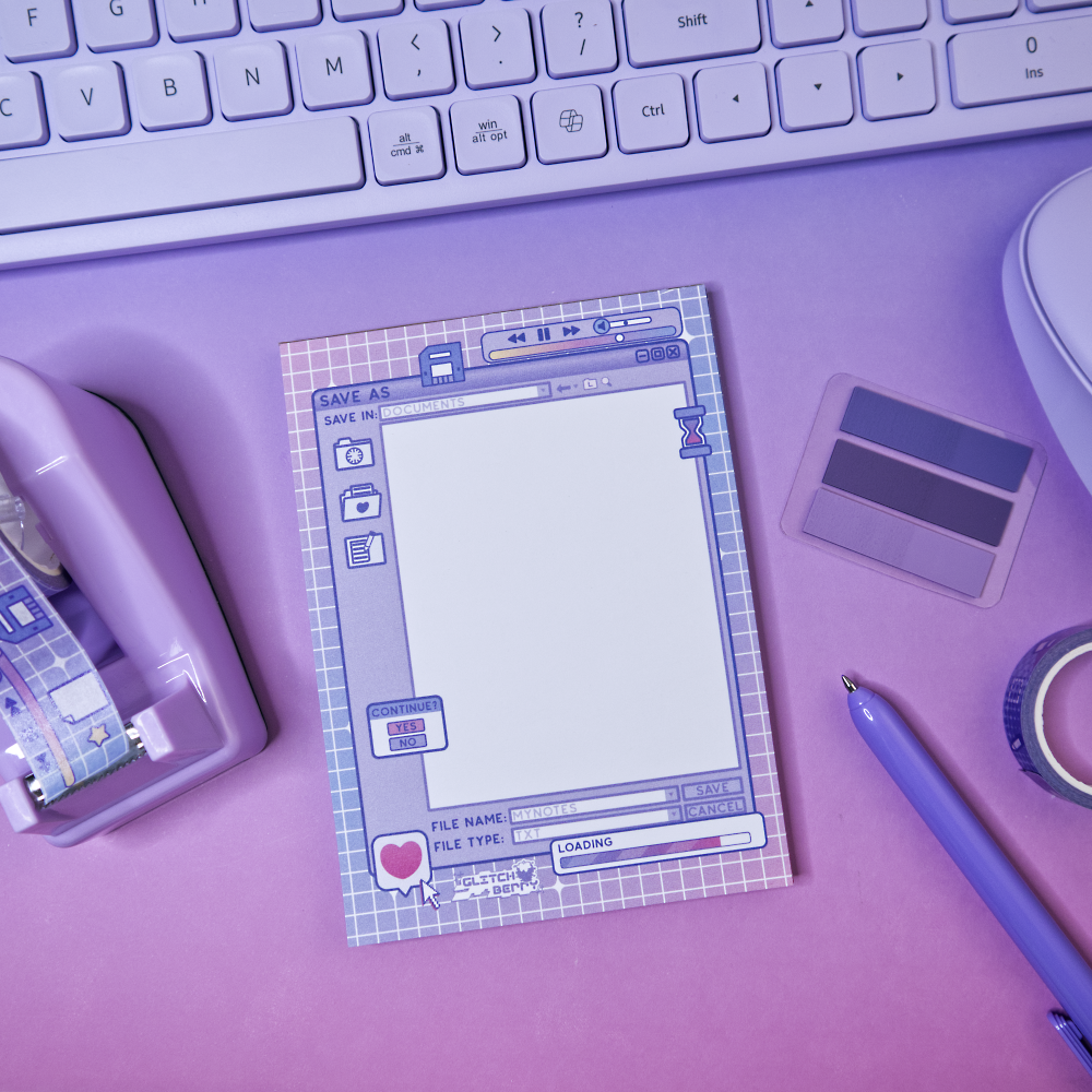 Notebook with retro computer interface design on a purple desk with keyboard, mouse, and washi tape.
