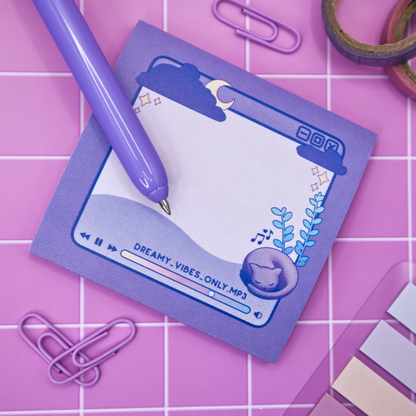 Purple sticky note pad with music player design featuring a cat and a plant on a pink grid background