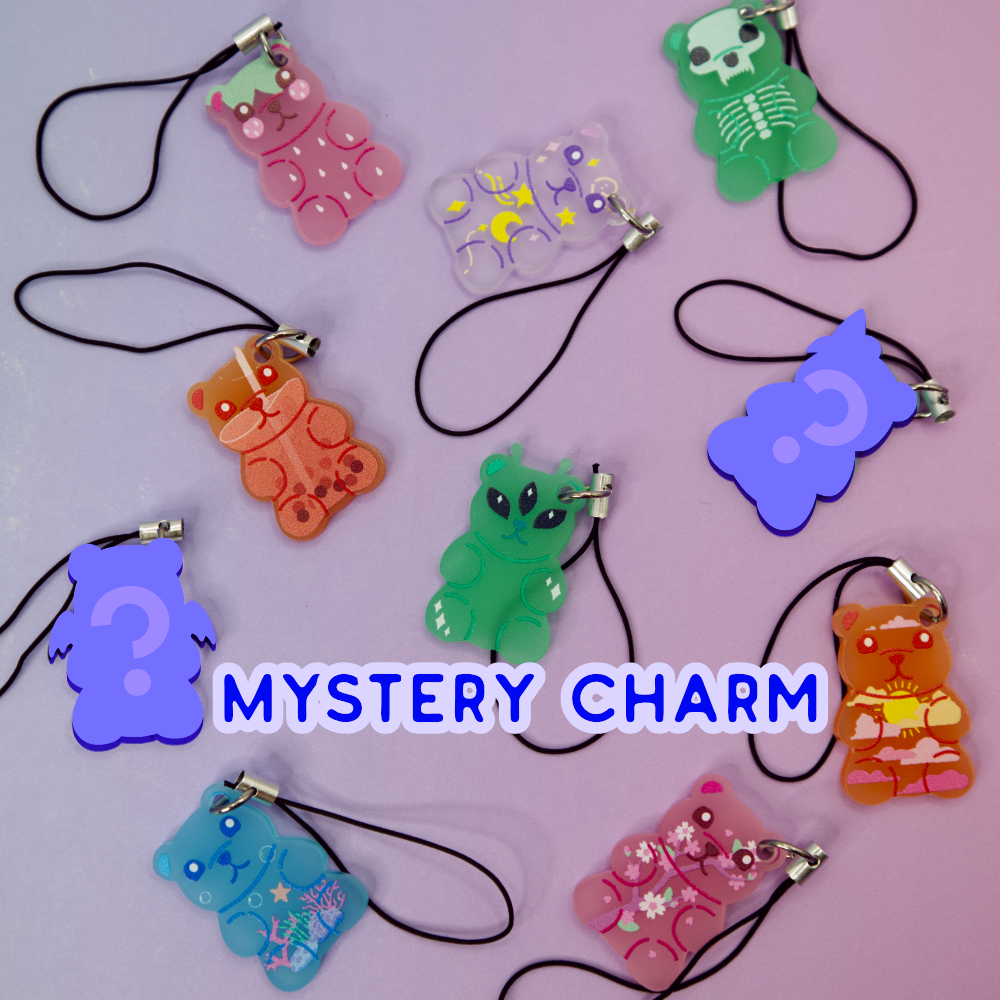 Colorful gummy bear-shaped phone charms on a light purple background with 'Mystery Design' text.  Two of the gummies are "mystery" designs and are silhouetted in purple with a question mark.