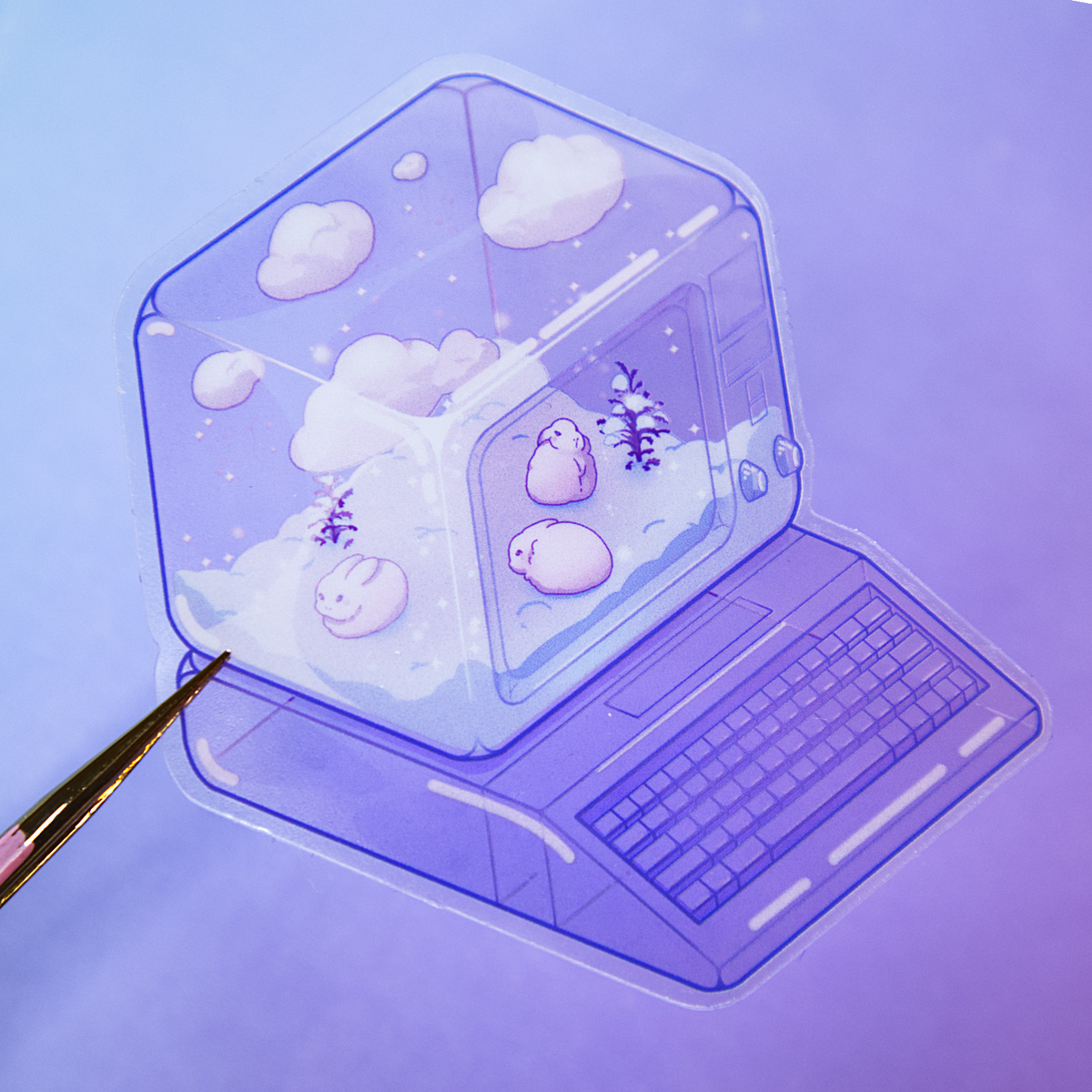 A pair of tweezers holds die-cut sticker featuring a winter scene with small rabbits, bare shrubs, and snow, inside of a translucent PC tower like a snow globe.  Sticker is photographed on a purple background.